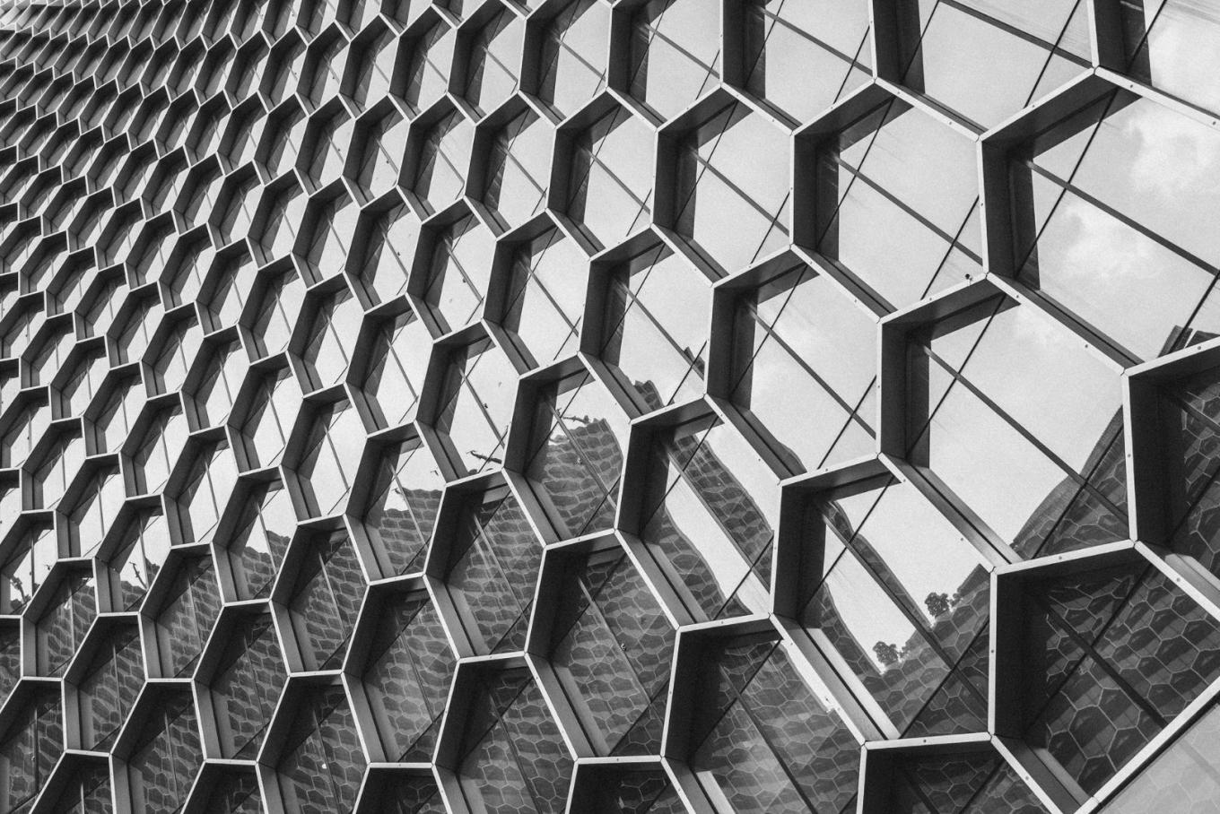 Metal grid on building with windows in hexagonal shape